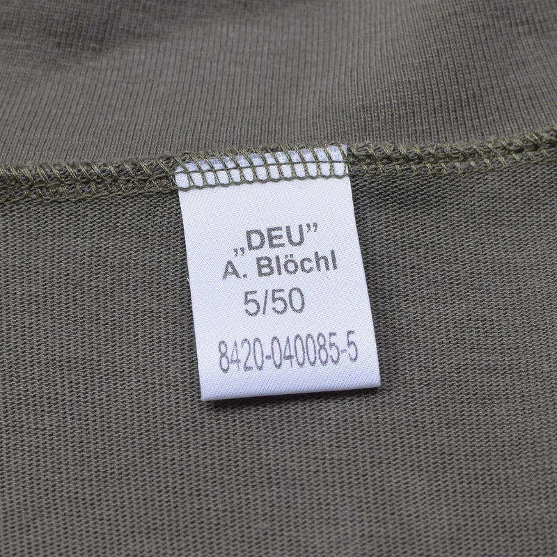 Close-up of white fabric tag on olive Blochl Brand military style thermal high neck jersey shirt with stitching details