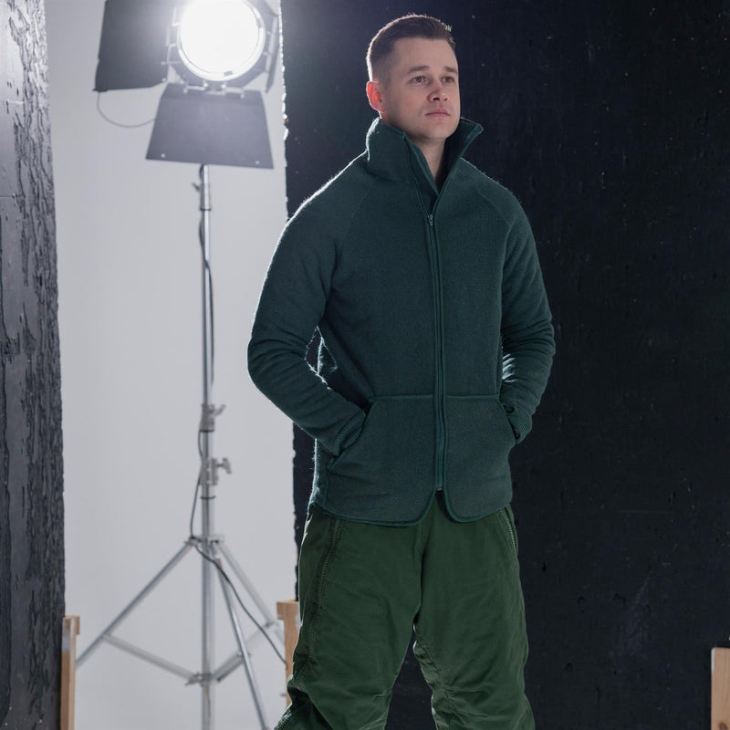 Man wearing green Dutch army thermal parka liner with full zipper and hand pockets in studio setting