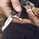 Close-up of Fox Knives VULPIS multitool showing N690Co steel blade, scissors, bottle opener, and screwdriver in use