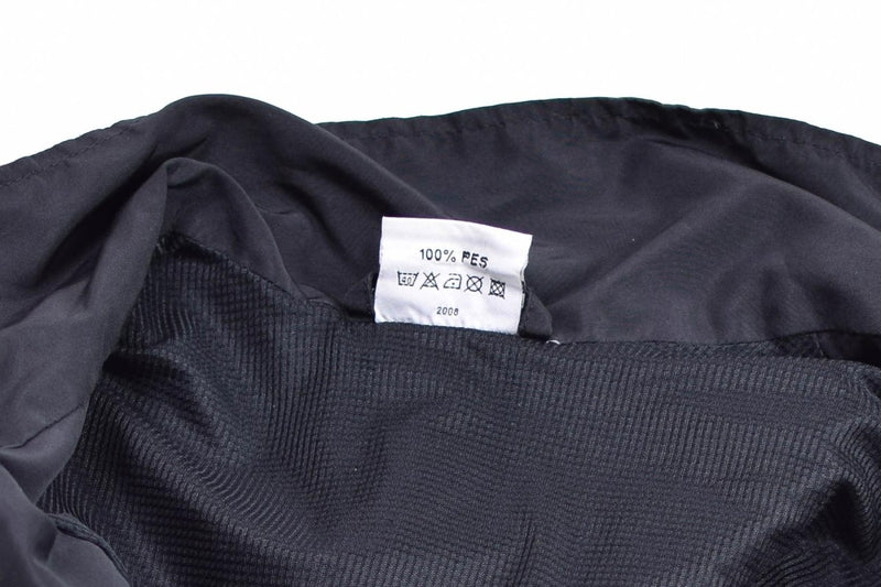 Close-up of the interior lining and care label of the Genuine Austrian Army Training Tracksuit Jacket in black fabric.