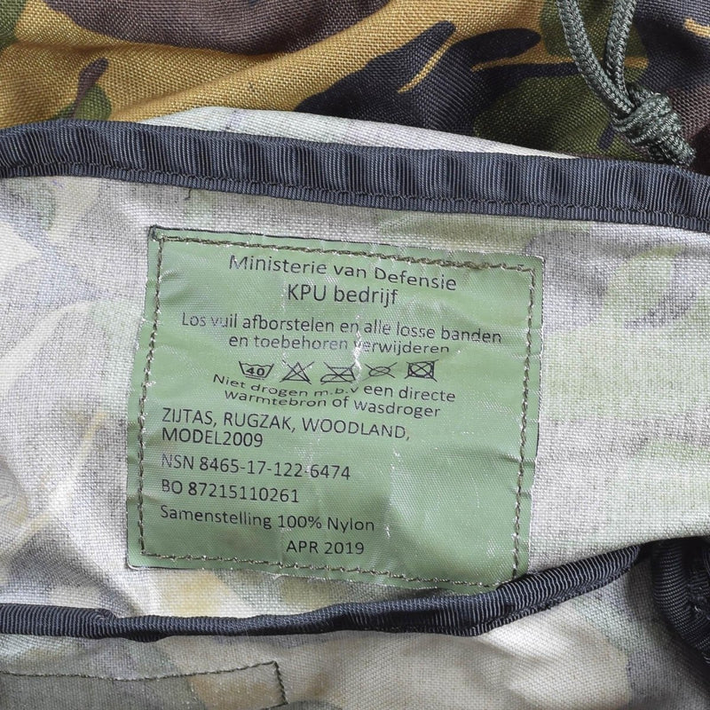 Close-up of the label inside Genuine Dutch Military woodland DPM backpack with model and care details visible
