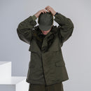 Man wearing genuine German Army military winter pile cap olive drab with matching cold weather jacket adjusting cap.