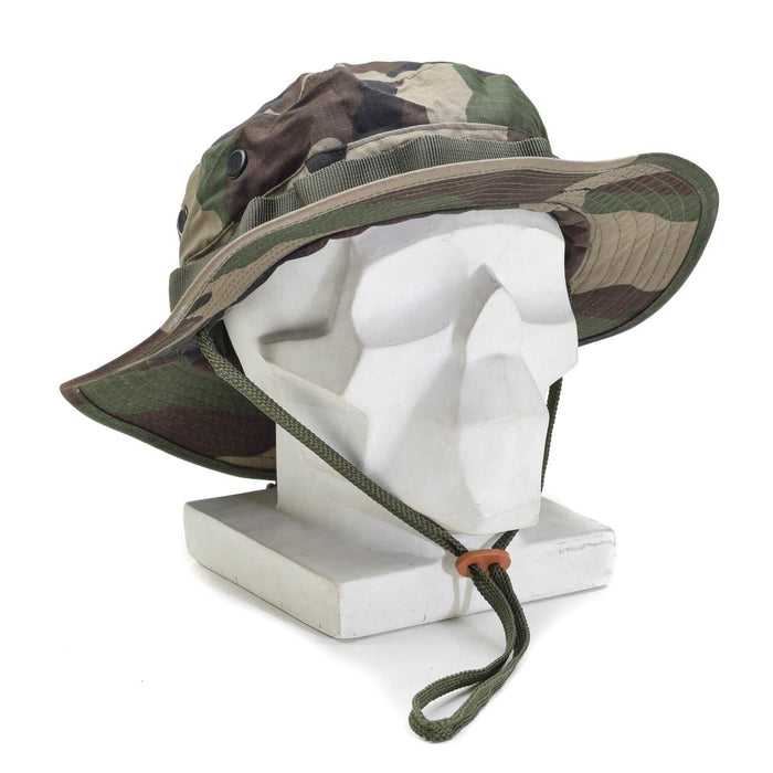 Cappello boonie militare leggero Mil-Tec con mimetica CCE, visiera pieghevole, tessuto ripstop e sottogola regolabile su espositore.
