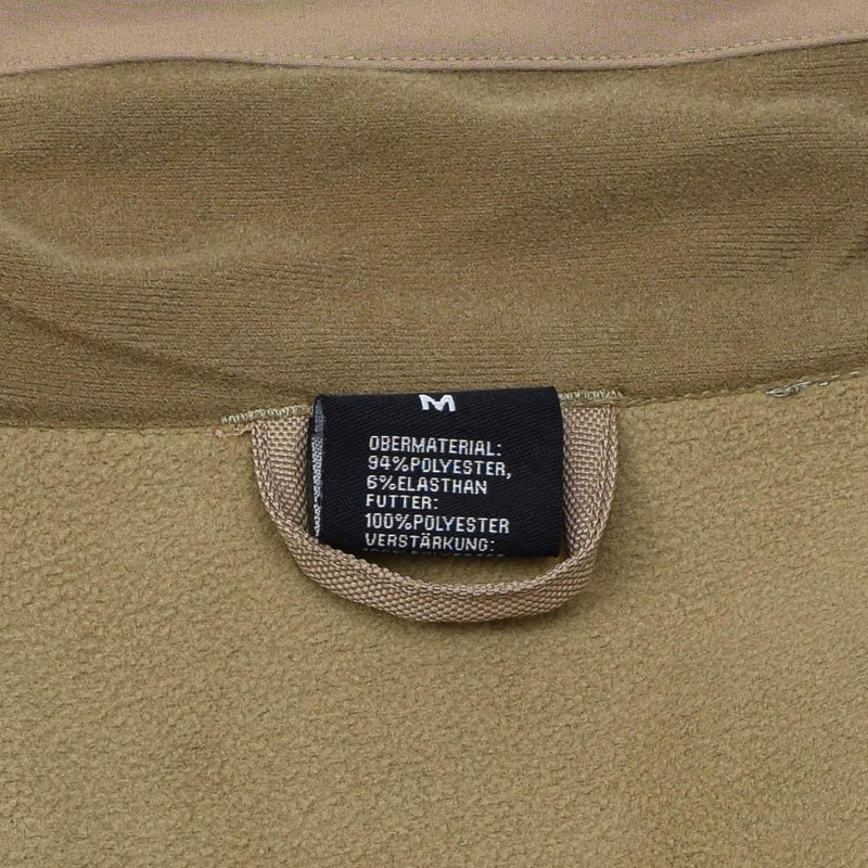 Close-up of MIL-TEC jacket label showing size medium and fabric composition of polyester and elastane.