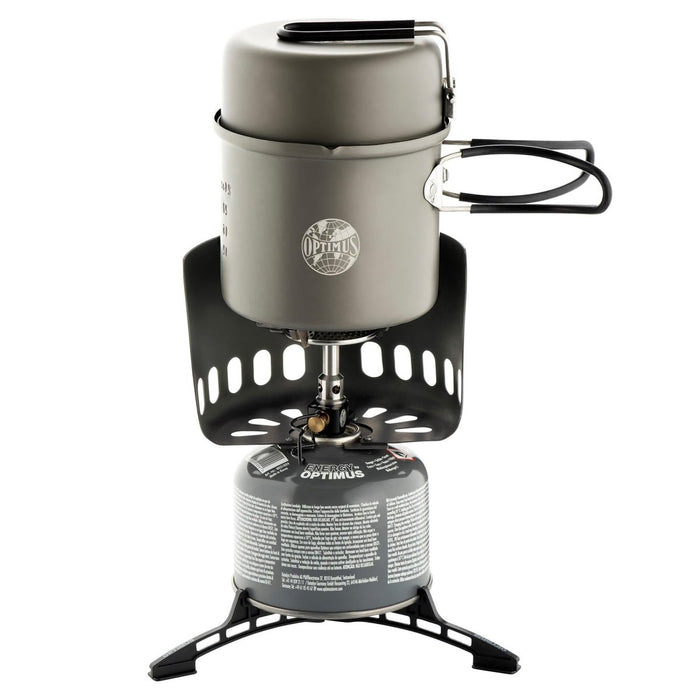 Fornello da campeggio compatto Optimus Elektra FE con pentola, padella, parabrezza e tanica di carburante, ideale per cucinare all'aperto.