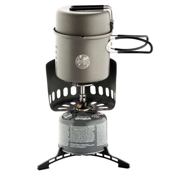 Optimus Elektra FE compact camping stove with pot, pan, windshield, and fuel canister, ideal for outdoor cooking.