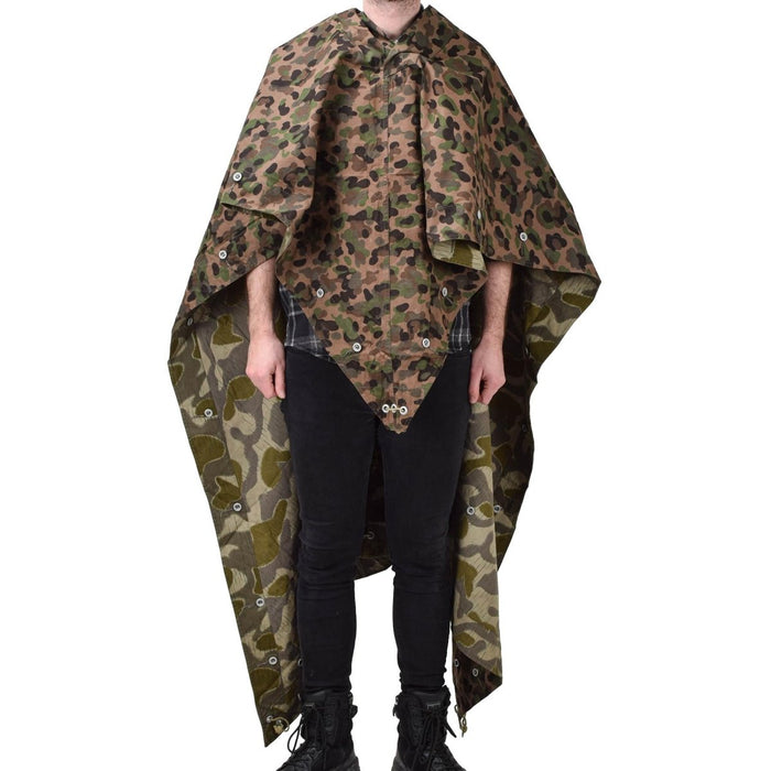 Persona che indossa una tenda poncho mimetica vintage a pois resistente all'acqua dell'esercito austriaco con lacci angolari