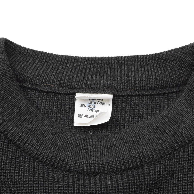 Close-up of dark green wool blend Belgian military sweater crew neck showing fabric texture and care label.