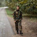 Man wearing Belgian military waterproof jigsaw camo rain trousers and jacket walking on forest road