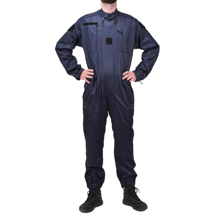 Tuta blu antistatica a tutta lunghezza da ufficiale di polizia francese con tasche multiple e polsini elastici indossata da una persona in piedi