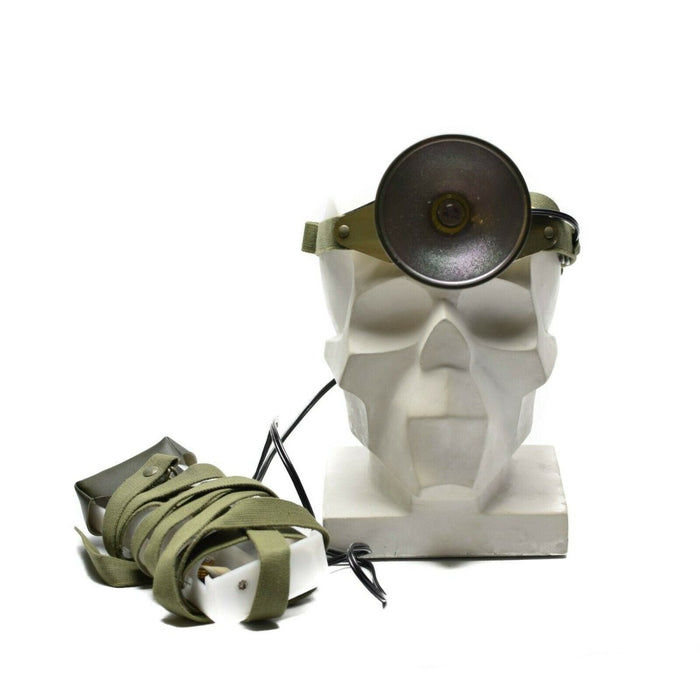 Teschio con lampada frontale con cinturino verde su sfondo bianco