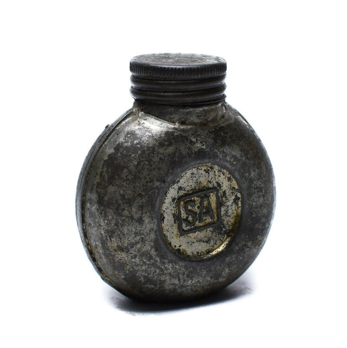 Boccetta d'inchiostro vintage in metallo con logo 'SA' su sfondo bianco